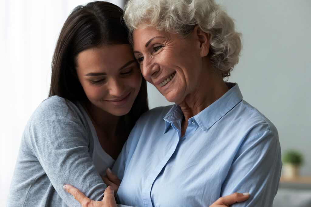 Grand daughter and grandmother embracing with a hug