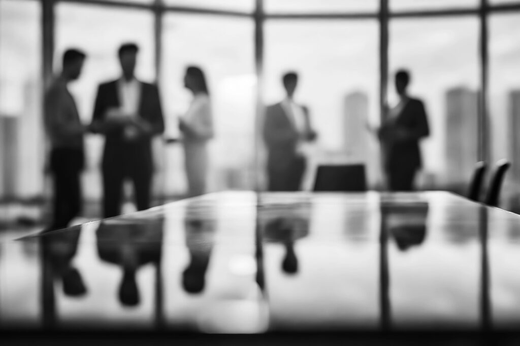 Business Team Meeting in a Modern Office at Sunset. Blurred silhouette of a business team having a meeting in a modern office with city skyline